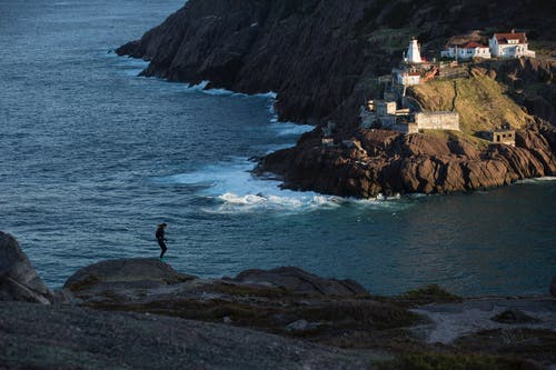 人站在悬崖上的剪影摄影 · 免费素材图片