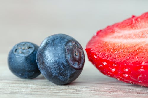 在两个蓝莓旁边的草莓 · 免费素材图片