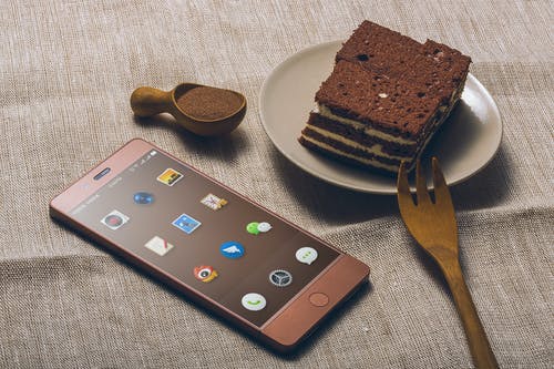 Iphone旁的飞碟上的巧克力蛋糕 · 免费素材图片