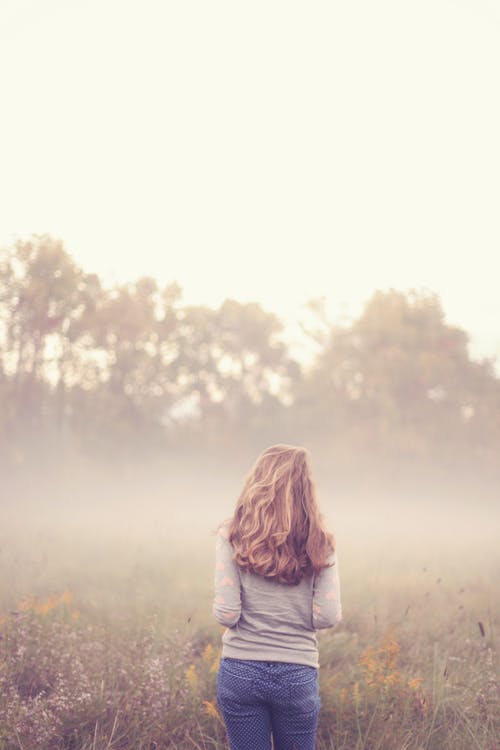 女人站在绿草前 · 免费素材图片