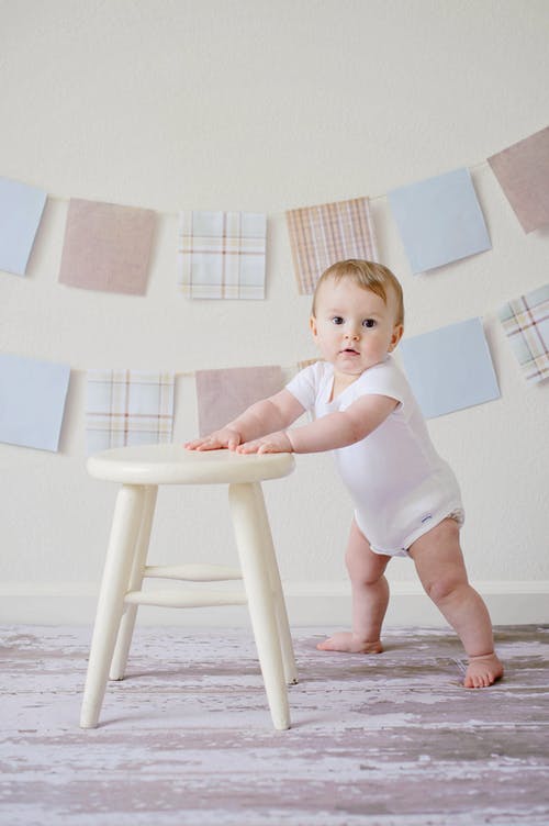 婴儿抱着白色的木凳 · 免费素材图片