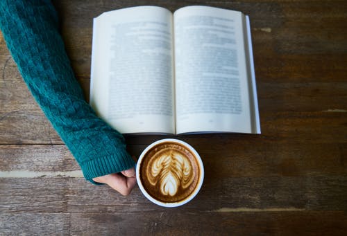 看书时喝杯拿铁咖啡的人 · 免费素材图片