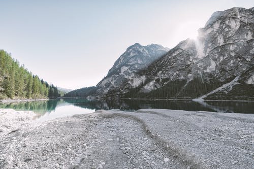 树与山之间的水体 · 免费素材图片