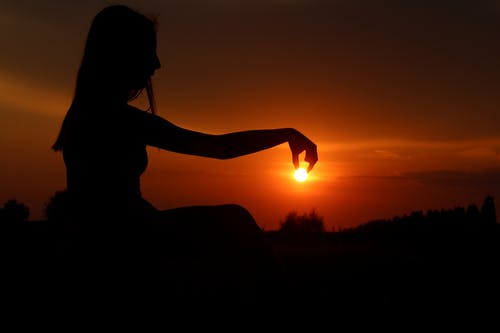 女人摘太阳的力透视摄影 · 免费素材图片