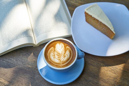 书和蛋糕旁边的咖啡拿铁咖啡 · 免费素材图片