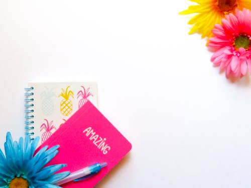 人造花附近书籍的平躺摄影 · 免费素材图片