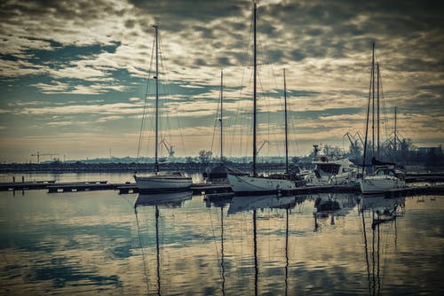 海洋码头附近的白色和黑色的小船 · 免费素材图片
