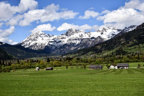 雪山附近的绿草田的风景摄影 · 免费素材图片