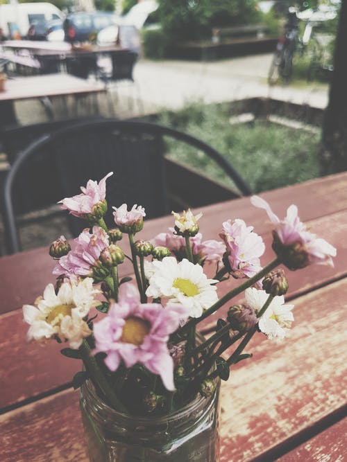 棕色木制的桌子上的花瓣花瓣插花 · 免费素材图片