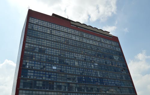 多云的蓝天下的蓝色混凝土高层建筑 · 免费素材图片