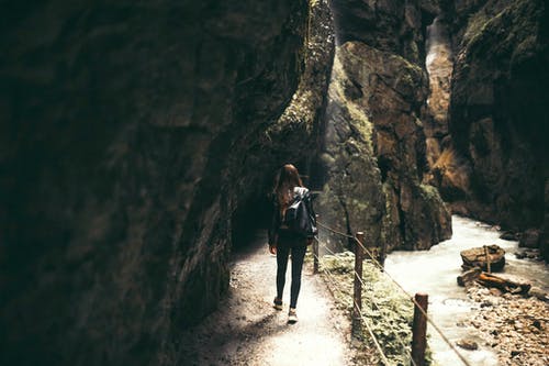 女人站在洞穴内 · 免费素材图片