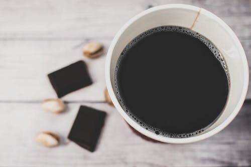 棕色木质表面上的白色聚苯乙烯杯 · 免费素材图片