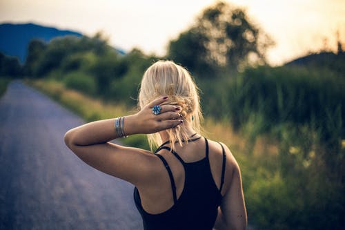 女人持有她的头发在户外 · 免费素材图片