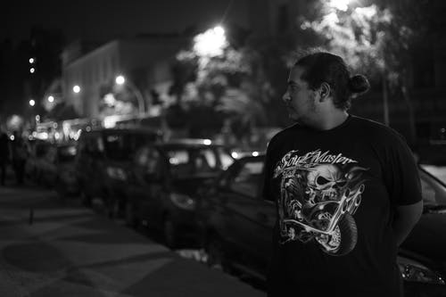 人站在车前的灰度照片 · 免费素材图片