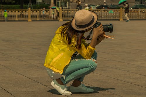 拍照时坐在人行道上的女人 · 免费素材图片
