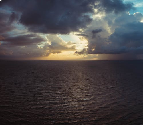 平静的水与雨云背景摄影 · 免费素材图片