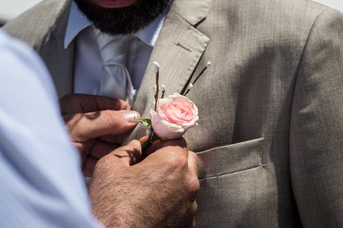 男人在男人的衣领上钉粉红玫瑰 · 免费素材图片