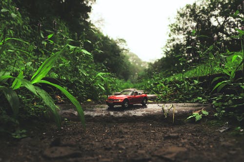 灰色混凝土板上的红色可转换比例模型 · 免费素材图片