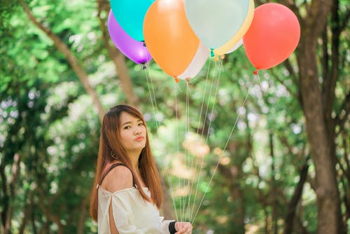女人拿着气球袋装她的嘴唇 · 免费素材图片