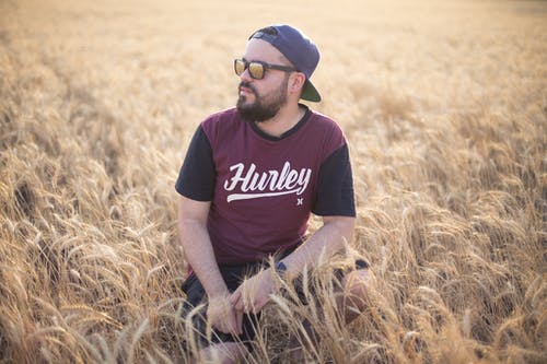 蹲在麦田的人的选择性聚焦摄影 · 免费素材图片