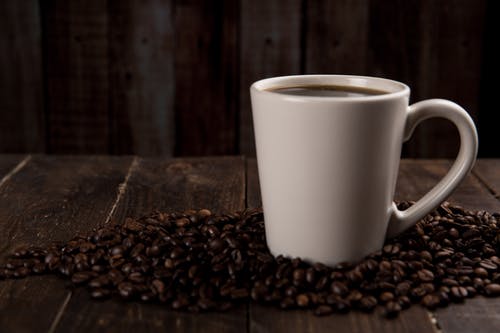 包围着咖啡豆的咖啡杯 · 免费素材图片