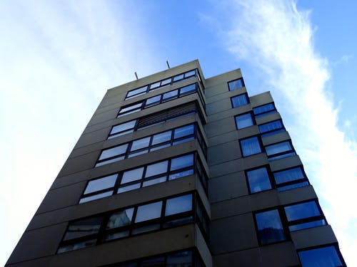 天空下的黑色高层建筑，充满了白云 · 免费素材图片