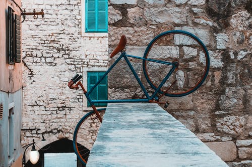 在混凝土栅栏上的蓝色自行车 · 免费素材图片