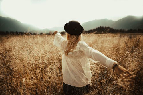 在褐色的草地上行走的女人 · 免费素材图片