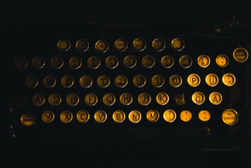 黄铜色打字机的平躺摄影 · 免费素材图片