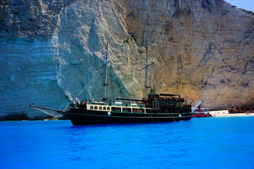 黑船在海上近岩层 · 免费素材图片