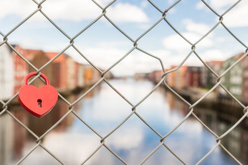 灰色链接围栏中的红色锁 · 免费素材图片