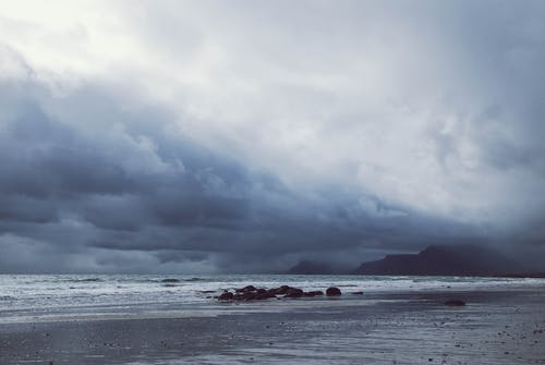 灰色多云的天空下的海洋 · 免费素材图片