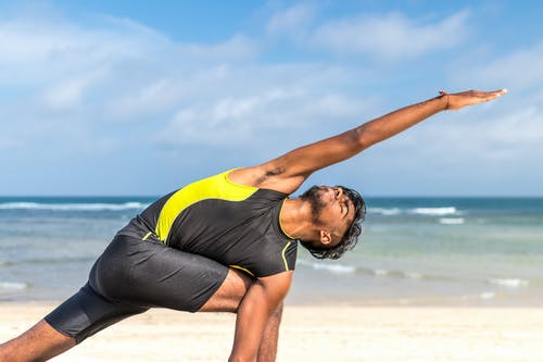 黄色和黑色背心白天在海边锻炼的人 · 免费素材图片