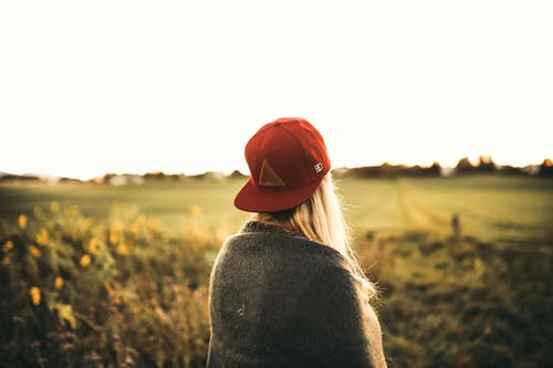 灰色开衫和红色后背帽的女人 · 免费素材图片