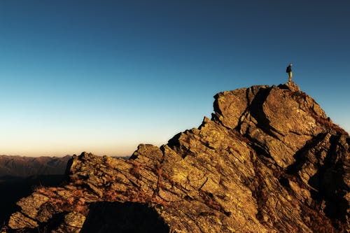 白天站在岩石上的男人 · 免费素材图片
