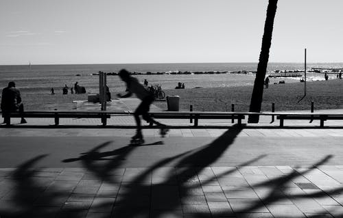 在灰度摄影的道路上滑冰的人 · 免费素材图片