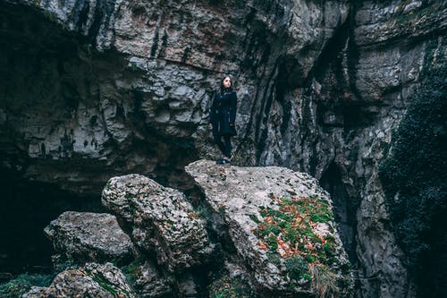 黑色衣服站在岩石上的女人的照片 · 免费素材图片