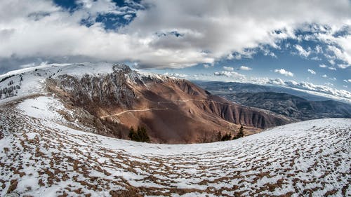 雪山在多云的天空下的风景照片 · 免费素材图片