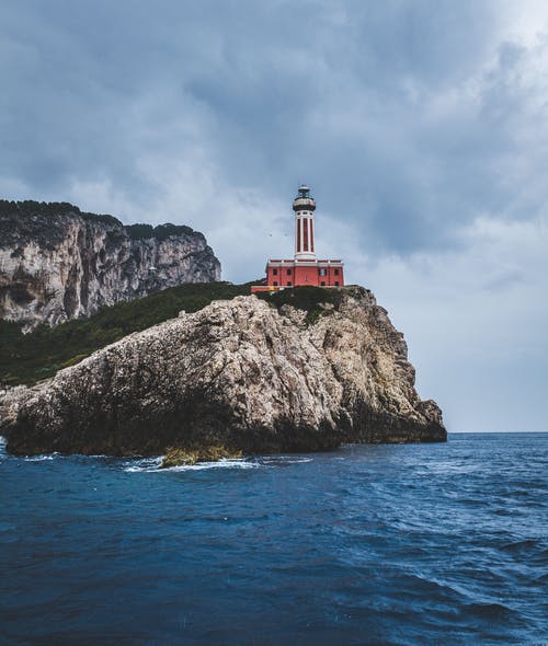 在海边的山顶上的红色灯塔 · 免费素材图片