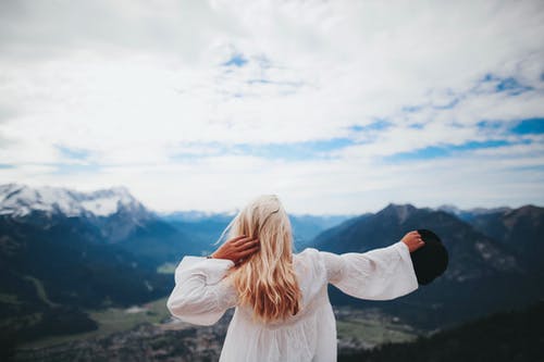 跨黑山穿白裙子的女孩 · 免费素材图片