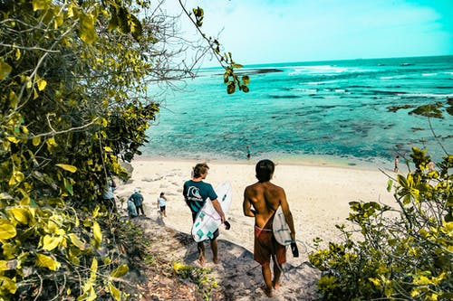 两个男人拿着冲浪板去海滩 · 免费素材图片