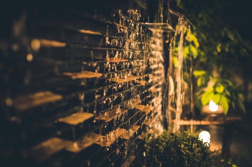夜间棕色砖墙的选择性聚焦摄影 · 免费素材图片
