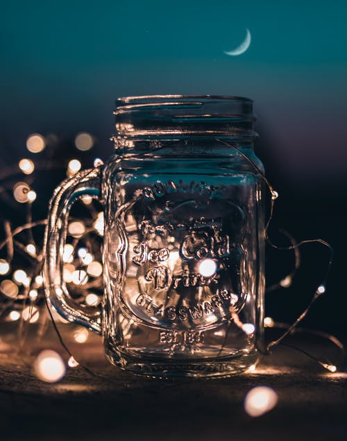 透明玻璃梅森罐带有童话般的灯光的浅焦点照片 · 免费素材图片