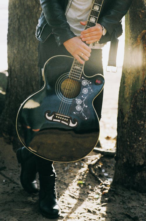 男子手持单切原声吉他 · 免费素材图片