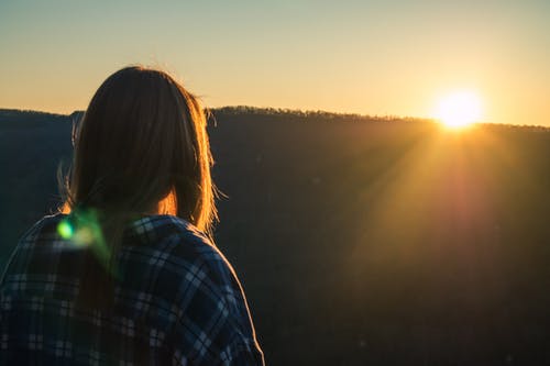 在黄金时段穿太阳的女人穿着格子衬衫 · 免费素材图片