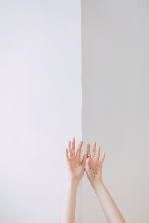 人两手倚在墙上 · 免费素材图片