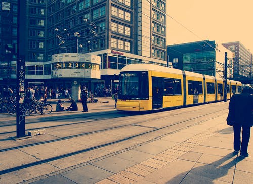 黄色火车在混凝土建筑物附近的选择性彩色摄影 · 免费素材图片