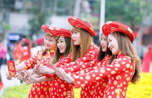 五名妇女在红色和白色的圆点旗袍礼服站 · 免费素材图片