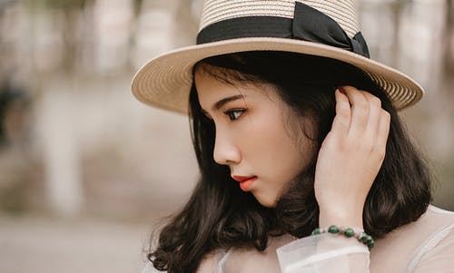 戴棕色太阳帽的女人的浅焦点摄影 · 免费素材图片