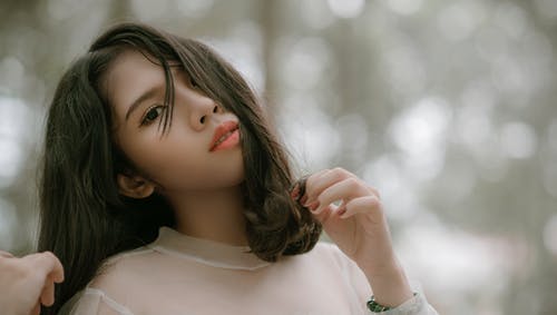 长长的黑发女人，穿着灰色上衣以自拍照 · 免费素材图片